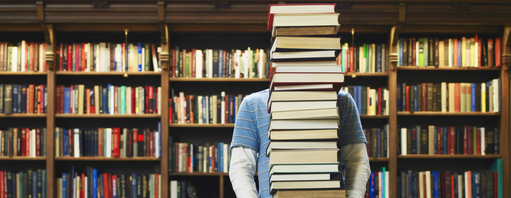 Student carrying stack of books